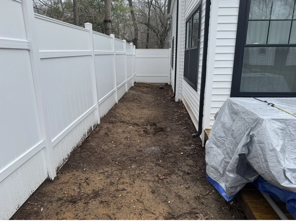 Before: bare soil beside white fence