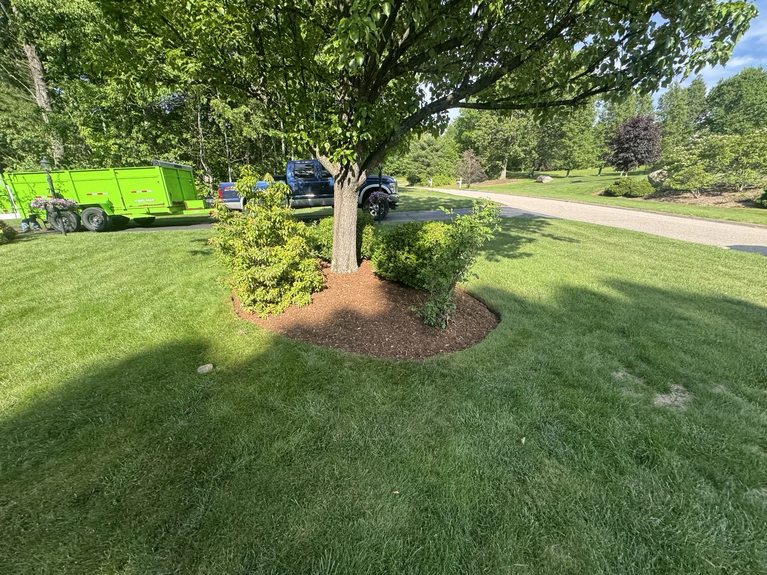Freshly mulched landscape bed and green lawn completed by J&B Landscaping
